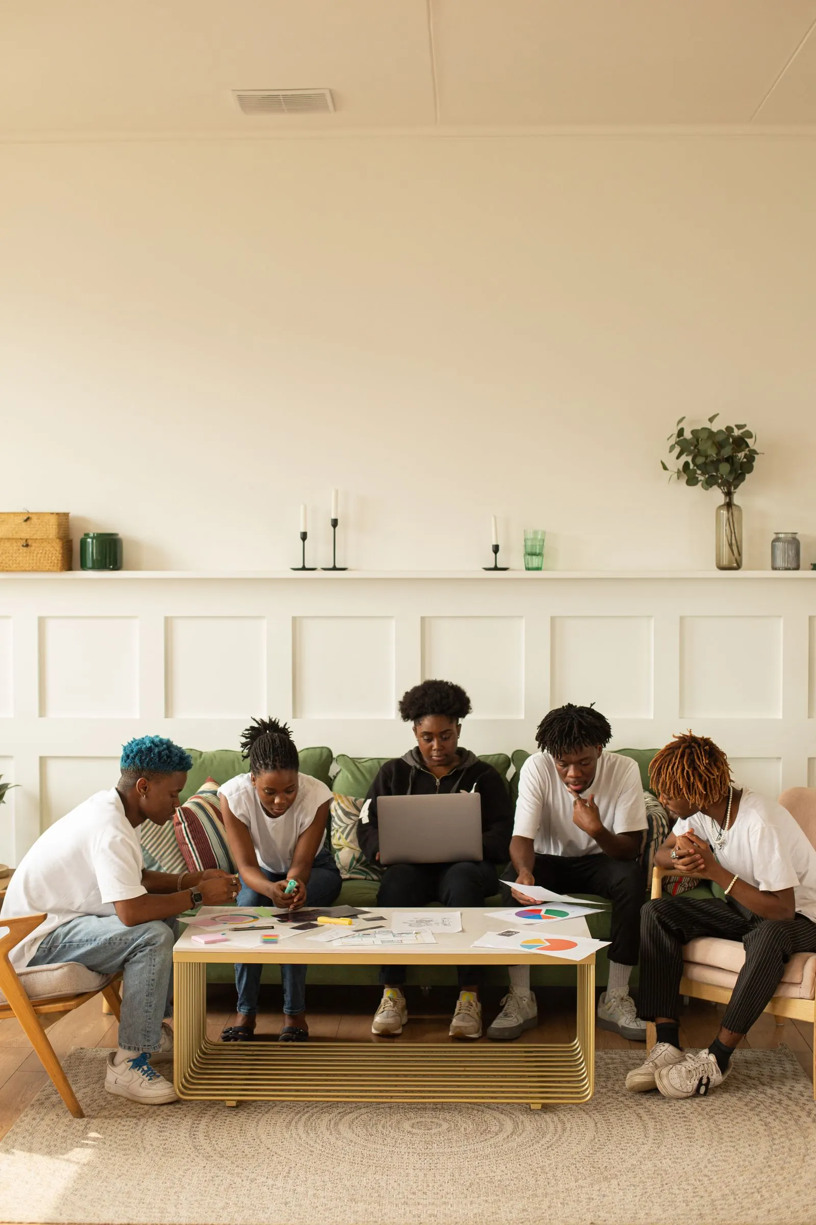 Young African professionals sitting together around laptops, sharing ideas in a bright modern workspace